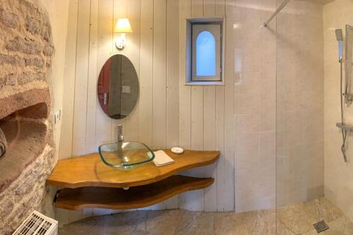 La salle de bains est pourvue d'un lavabo en verre et d'une douche. dans l'établissement Le patio du Château de Thanvillé, à Thanvillé