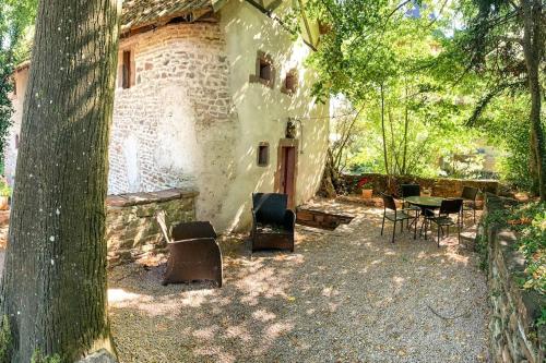 un bâtiment avec des chaises, une table et un arbre dans l'établissement Le patio du Château de Thanvillé, à Thanvillé