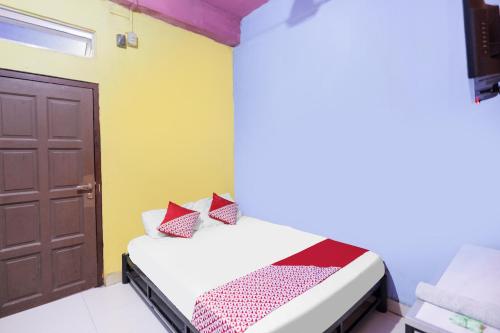 ナゴヤにあるSPOT ON 91887 Penginapan Rinduの小さなベッドルーム(ベッド1台、ドア付)