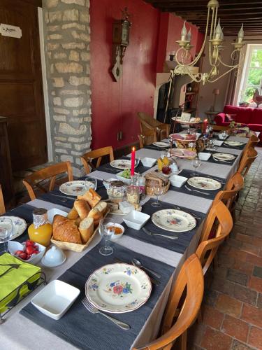 a long table with plates of food on it at Chambres d'Hotes Raviere in Bouhy