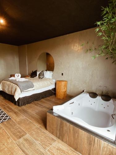 a bedroom with a bed and a bath tub at Pousada Cafe Poesia in Campos do Jordão