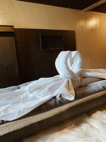 a bed with white towels on top of it at Pousada Cafe Poesia in Campos do Jordão