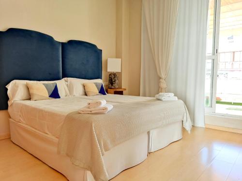 a bedroom with a large bed with a blue headboard at Penthouse Cathedral Tomas de Ibarra St 6 pax, Parking Optional in Seville