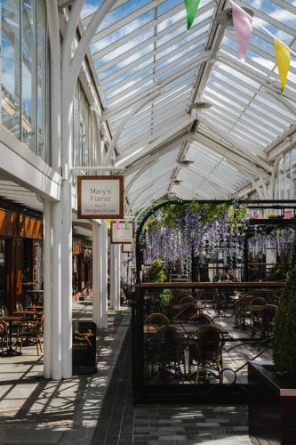 a mall with tables and chairs and a glass ceiling at Prescott Court by Guestz in Halifax