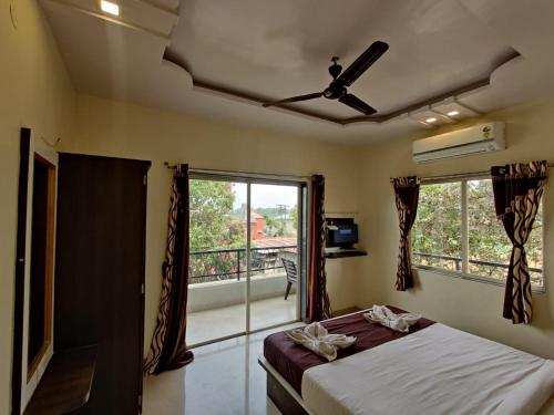 sypialnia z łóżkiem i oknem z balkonem w obiekcie Hotel Nisarg w mieście Panchgani