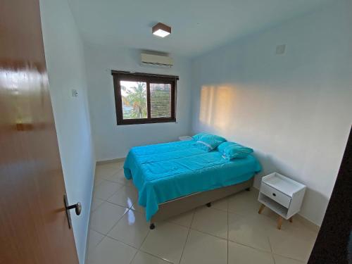 um pequeno quarto com uma cama e uma janela em Apto no centro de Tibau com vista para lagoa/mar em Pipa