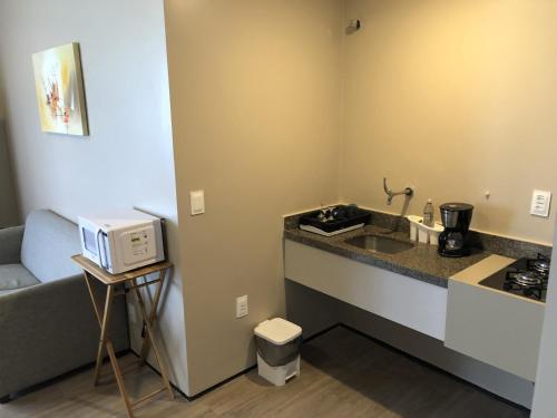 a kitchen with a sink and a microwave at Particular Golden Beira Mar in Fortaleza