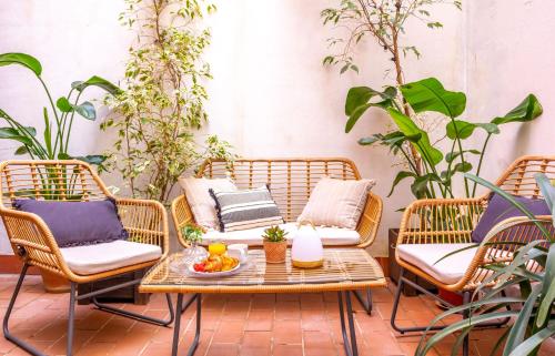 eine Terrasse mit einem Tisch, Stühlen und Pflanzen in der Unterkunft Great location in the historical center in Sevilla