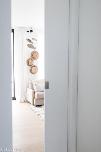 a living room with a white couch and a window at La Naturale Garden zeezicht in Zeebrugge