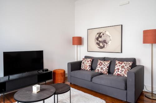 - un salon avec un canapé et une télévision dans l'établissement Akicity Ourique Rose, à Lisbonne