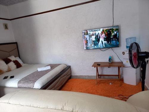 a hotel room with two beds and a fan at Nash Studio AirbnB in Nakuru