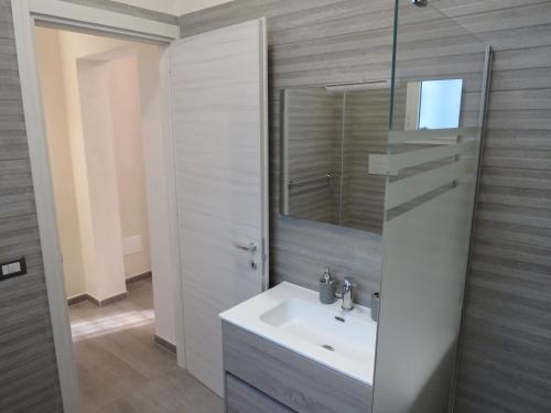 een badkamer met een wastafel en een spiegel bij Casa Veneto in Mazara del Vallo