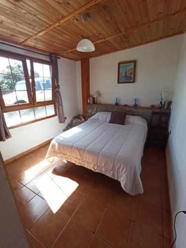 a bedroom with a large bed with a wooden ceiling at Casa de los abuelos in Vilaflor