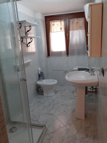 a bathroom with a sink and a toilet and a shower at Cià Evelina in SantʼAntìoco