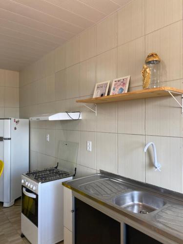 a kitchen with a sink and a stove at Apartamento Maragogi - CENTRO in Maragogi