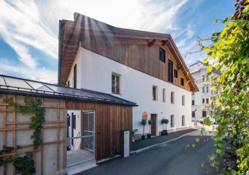 a house with a wooden roof on a street at pradl elf my- apartment in Innsbruck
