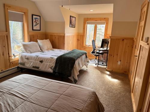 een slaapkamer met een bed en een bureau. bij Loafers' Lodge in Carrabassett