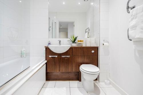 a bathroom with a sink and a toilet and a tub at 2-Bed Apartment Near Basildon Train Station in Basildon