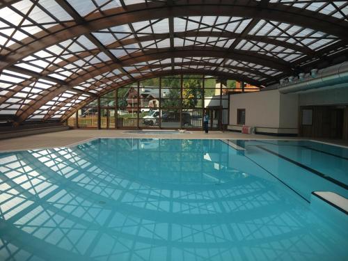 une grande piscine avec un grand plafond dans l'établissement Lodge Alouette, à Champagny-en-Vanoise