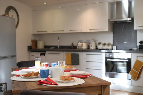 a kitchen with a table with plates of food on it at Burgess Yard 2-bedroom cottage, Bath in Bath
