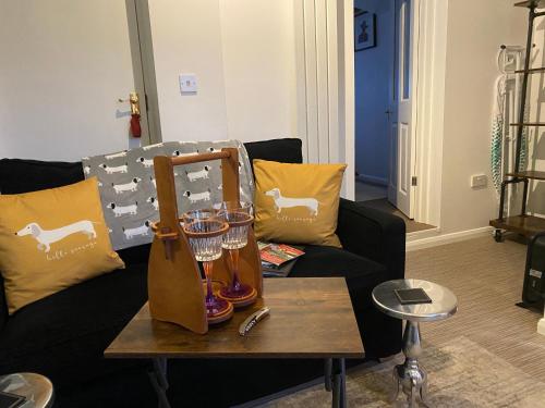 a living room with a couch and a table with wine glasses at Self-contained, Framlingham Snug, Private Parking, no cooking facilities in Framlingham