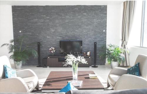 a living room with a table and a tv at Butterfly Residence in Manama