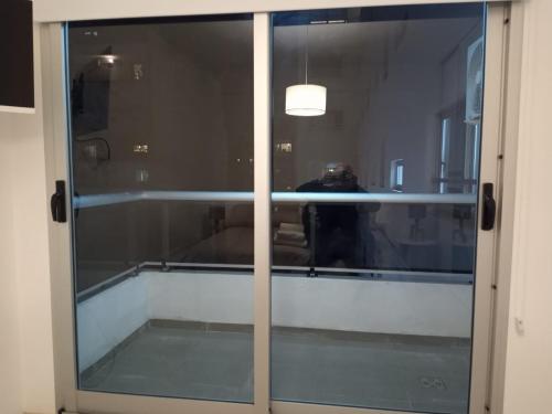 una puerta corredera de cristal con un reflejo de una persona detrás de ella en Cabildo Complete Suite 3 en Buenos Aires