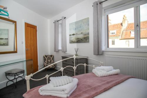 1 dormitorio con cama, ventana y escritorio en Burgess Yard 2-bedroom cottage, Bath, en Bath