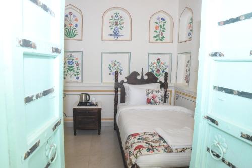una camera con un letto e alcune immagini sul muro di KothiPushkar a Pushkar