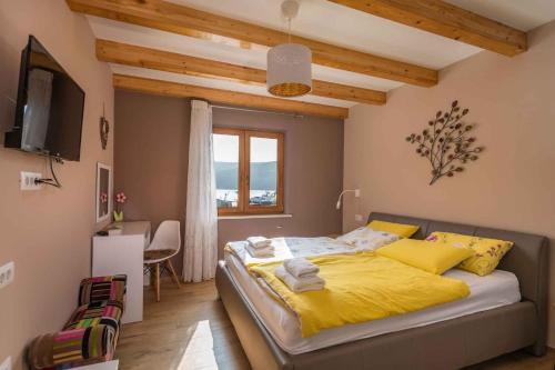 sypialnia z łóżkiem z żółtą pościelą i oknem w obiekcie Holiday home in Krnica/Istrien 38131 w mieście Krnica