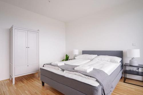1 dormitorio blanco con 1 cama y armario en Oberlaa New Apartment - 15 Min to City, en Viena
