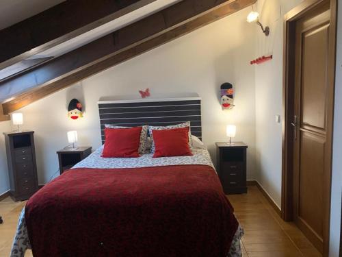 a bedroom with a large bed with red pillows at La Perseverancia in Aldehuela