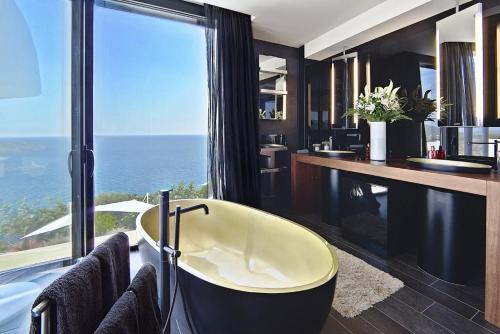 a bathroom with a tub and a view of the ocean at Irresistible Ibiza Villa 3 Bedrooms Villa Buena Private Heated Pool & Underfloor Heating San Jose in Sant Josep de sa Talaia