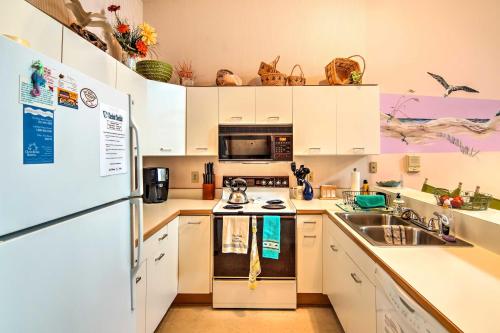 a kitchen with white cabinets and a sink and a refrigerator at Kitty Hawk Townhome at Sea Dunes - Walk to Beach! in Kitty Hawk