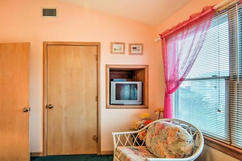 a room with a chair and a television and a window at Kitty Hawk Townhome at Sea Dunes - Walk to Beach! in Kitty Hawk