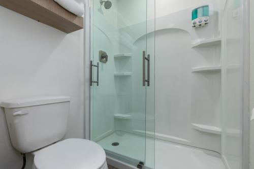 a bathroom with a toilet and a glass shower at Bluff's Landing Marina & Lodge in Flour Bluff