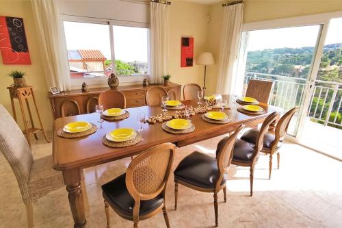 a dining room table with chairs and a large window at VILLA VALENTINA in Mataró