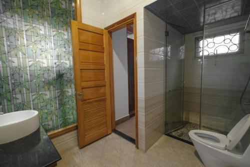 a bathroom with a toilet and a glass shower at Le Robinet Villa - a journey into Hue citadel soul in Hue