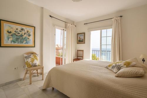a bedroom with a large bed and a window at Exclusive Villa - Great Sea View in Nerja