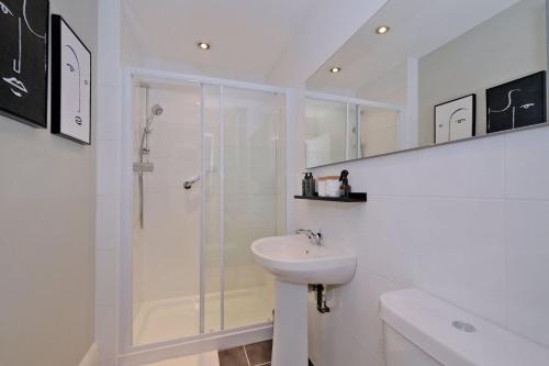 a white bathroom with a shower and a sink at Granton Place in Aberdeen