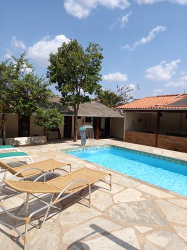 uma villa com uma piscina e mobiliário de pátio em Brisa da Serra Hotel Pousada Pirenopolis em Pirenópolis