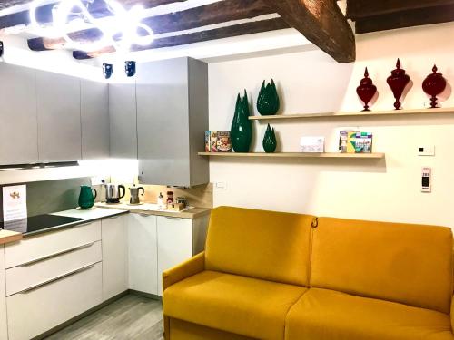 a living room with a yellow couch in a kitchen at Cà dei Santi- BIENNALE in Venice