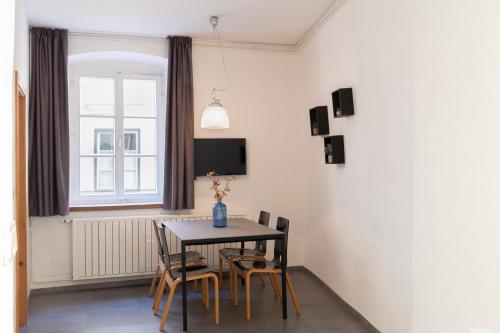 a dining room with a table and chairs and a window at Alter Schlachthof in Bressanone