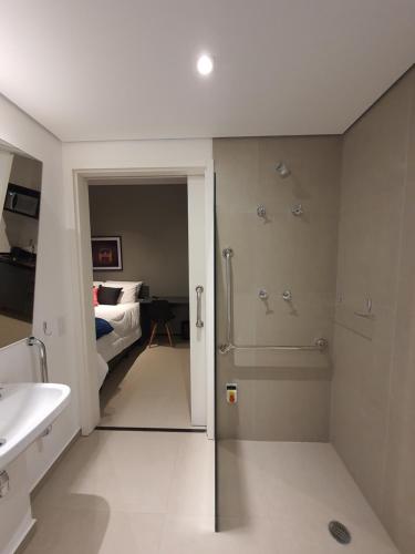 1 cama y baño con ducha y lavabo. en Studio Allianz Perdizes en São Paulo