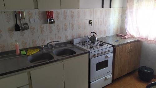 a kitchen with a stove and a sink at Casa de vacaciones Faro 1 in Mar del Plata