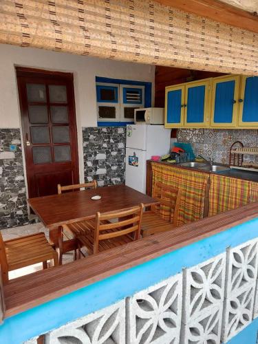 a kitchen and dining room with a wooden table at Meryem in La Trinité