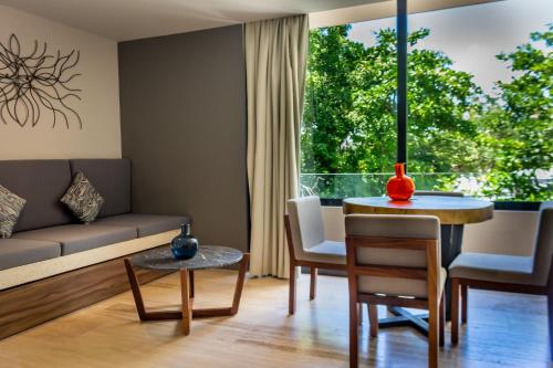 プラヤ・デル・カルメンにあるBig Studio at KAAB BY THE BEACH with roof top pool, sauna and Jacuzzi near Paseo del Carmen Mallのソファとテーブルのあるリビングルーム