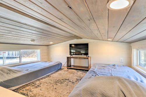 1 dormitorio con 2 camas y TV de pantalla plana en Tiny Home Retreat with Fire Pit about 3 Mi to Lake! en Morganton