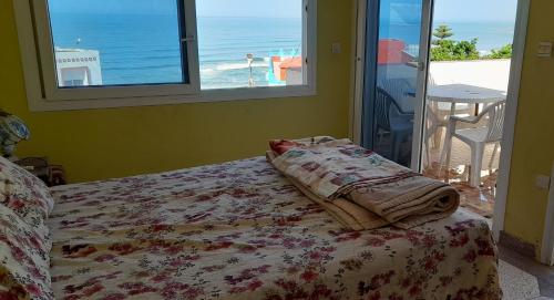 a bedroom with a bed with a view of the beach at Riad beach house in Mirleft