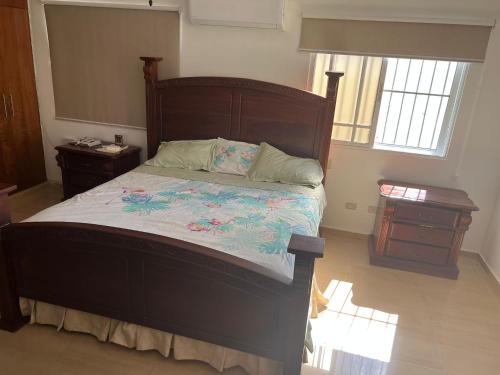 a bedroom with a large bed and a night stand at Villa Caterina in Dajabón